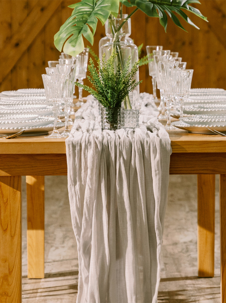 Glasses flatware and china on a table cloth with beautiful flowers for rent